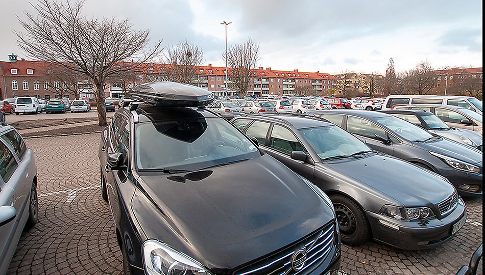 Bilar står parkerade på en parkeringsplats. Foto. 